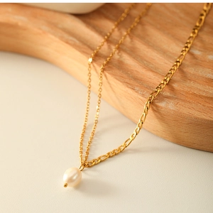 Detail shot of double-layered 18K gold titanium necklace with elegant pearl pendant