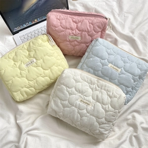 Close-up of heart-shaped quilted texture and zip closure on macaron fabric makeup bags