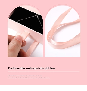 Detailed close-up of a pink drawer jewelry gift box with a pink silk ribbon handle
