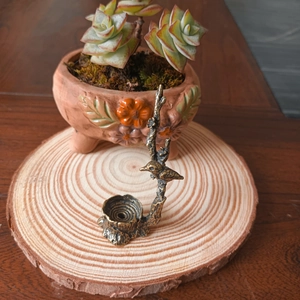 Détail d'un porte-encens en laiton en forme d'oiseau sur un socle en bois de style Zen