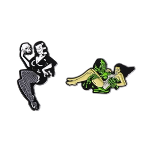 Gothic girl holding skull and creature from black lagoon enamel pin set on white base