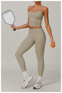 Women's padded yoga top and leggings with pickleball racket in khaki gym scene