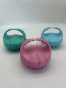 Close-up of ergonomic silicone scalp massage brushes in pink, cyan, and blue colors
