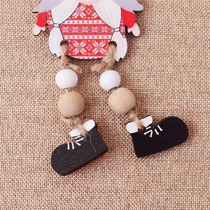 Macro detail of wooden Christmas gnome ornament with red snowflake pattern and jute rope legs