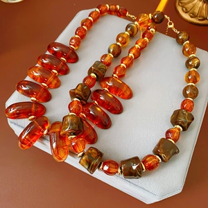 Detailed view of irregular geometric amber beads on a vintage gold-toned link necklace