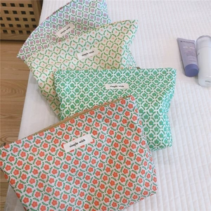 Close-up of four floral cotton cosmetic bags with colorful patterns and golden zippers