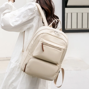 Minimalist cream nylon backpack for women featuring multiple zipper pockets and a causal style
