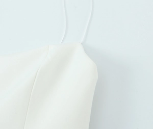 Close-up of white elastic dress with fine stitching and slim shoulder strap detail
