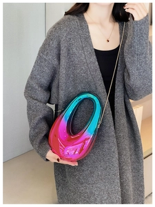 Detail of gradient blue and magenta acrylic handbag with metallic chain and glossy finish