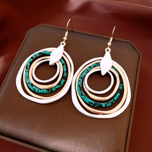 Close-up of bohemian layered hoop earrings with blue speckled rings on silk background