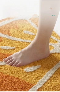 Close-up of soft orange fruit pattern bath mat with plush texture and non-slip backing