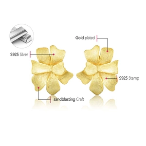 Detail of S925 sterling silver flower earrings with sandblasted golden matte finish texture