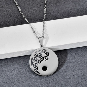 Macro detail of silver stainless steel Tai Chi necklace with hollow Flower of Life pendant