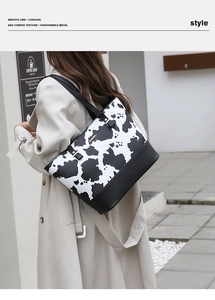 Detail of fashion tote bag with cow print pattern and premium black leather patchwork