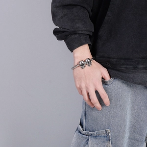 Détail d'un bracelet en acier à double crâne vintage avec cordon noir sur poignet masculin
