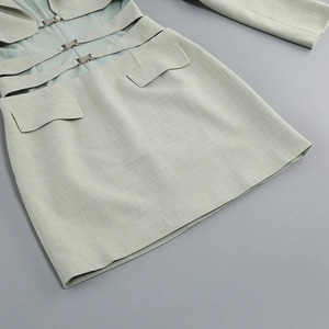 Détail de la robe vert menthe avec découpe à la taille, boucle en métal et poches