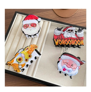 Detail view of four Christmas-themed hair claws with Santa Claus and gnome designs