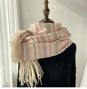 Close-up of thick pastel rainbow plaid scarf with long fringe details and soft texture