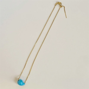 Detail of adjustable gold box chain with blue teardrop pendant and sliding metal bead