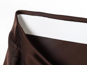 Detail of coffee-colored lace skirt showing white elastic waistband and stitching quality