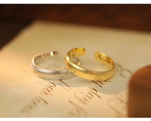 Detail of gold and silver S925 rings with wavy texture on a vintage background