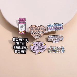 Set of 7 colorful enamel pins featuring mental health themes on a white ceramic tray
