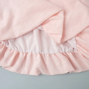 Gros plan sur tissu en lin rose avec ourlet à volants et doublure intérieure assortie