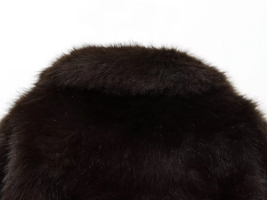 Gros plan sur la texture en fausse fourrure douce du col d'un manteau marron foncé chic