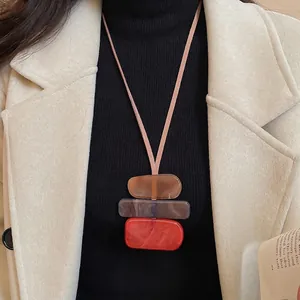 Long sweater necklace with colorful acrylic geometric pendants on a delicate brown cord