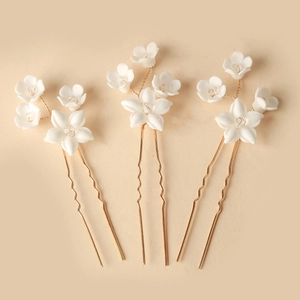 Three-piece bridal hair pin set with white ceramic flowers and crystal centers