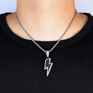 Gros plan du pendentif éclair hip-hop avec pierres bicolores sur une chaîne argent