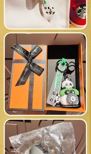 Dettaglio del portachiavi panda con cinturino verde presentato in confezione regalo