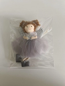 Detail of angel plush doll with mesh skirt and silver wings in protective packaging