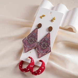 Detail of bohemian earring set with wood rhombus drops and red polka dot fabric hoops