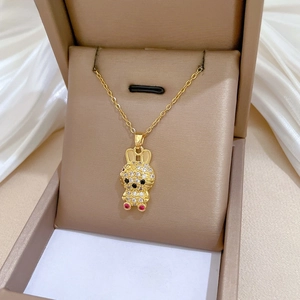 Macro detail of gold rabbit necklace with pavé zircon stones in a gift box
