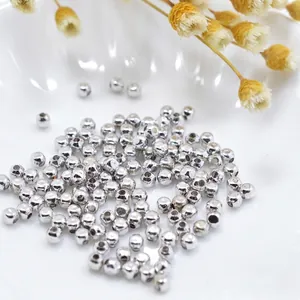 Polished silver metal spacer beads for DIY jewelry making in a white ceramic bowl