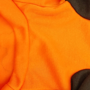 Detailed macro view of orange and dark knit fabric texture for dog vest and t-shirt apparel