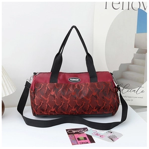 Detail of red camouflage travel bag with adjustable black shoulder strap and logo