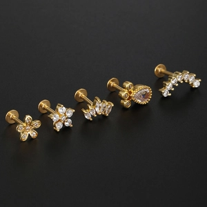 Detailed macro view of five gold-tone stainless steel ear piercings with clear zircon gems
