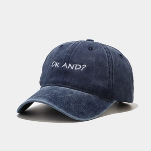 Detailed close-up of OKAND white embroidery on vintage navy washed cotton baseball cap