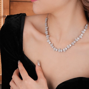 Close-up of elegant silver necklace with teardrop zircon stones on model's neck