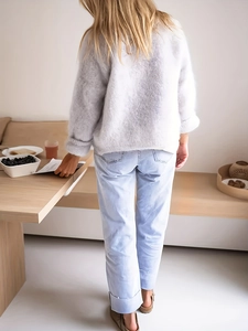 Detalle de cárdigan de felpa gris suave combinado con jeans de mezclilla rectos azul claro