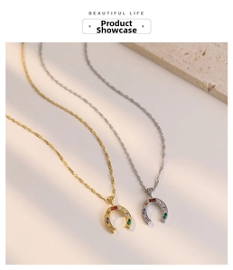 Macro detail of horseshoe pendant with multi-color zircons on gold and silver chain