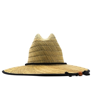 Detail of woven straw sun hat featuring a black edge trim and adjustable chin strap