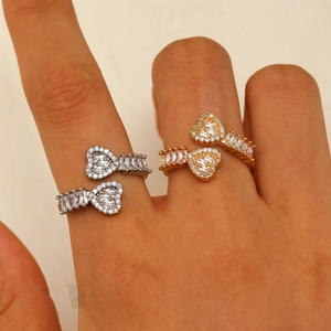 Close-up of gold and silver heart rings with cubic zirconia details worn on fingers