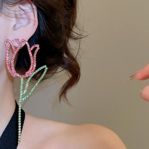Close-up of a large hollow tulip earring with sparkling pink and green rhinestones