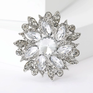 Macro shot of silver flower brooch featuring sparkling marquise and round cut crystals