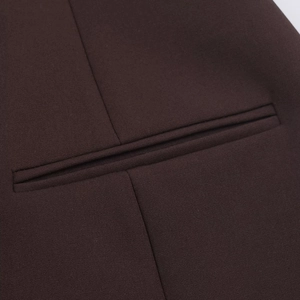 Close-up of jetted pocket detail on dark brown short dress with woven texture fabric
