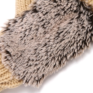 Close-up detail of knitted winter plush hedgehog mittens, showing soft texture and cozy fabric.