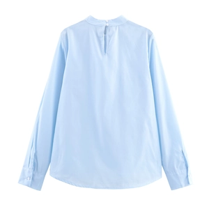 Back view of light blue high neck long sleeve blouse with bow and cutout button detail